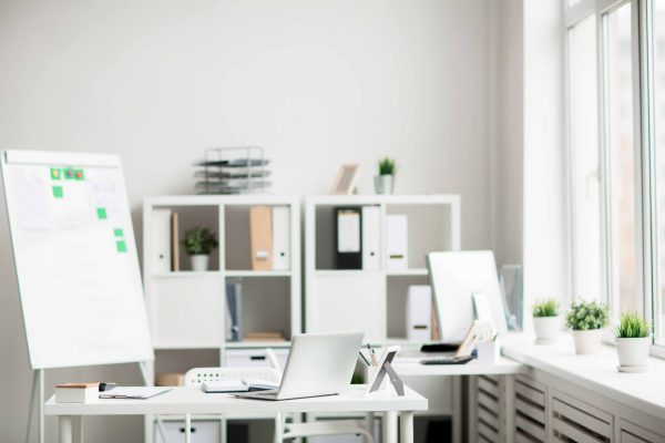 Workplace with laptop and stationary supplies in empty modern office